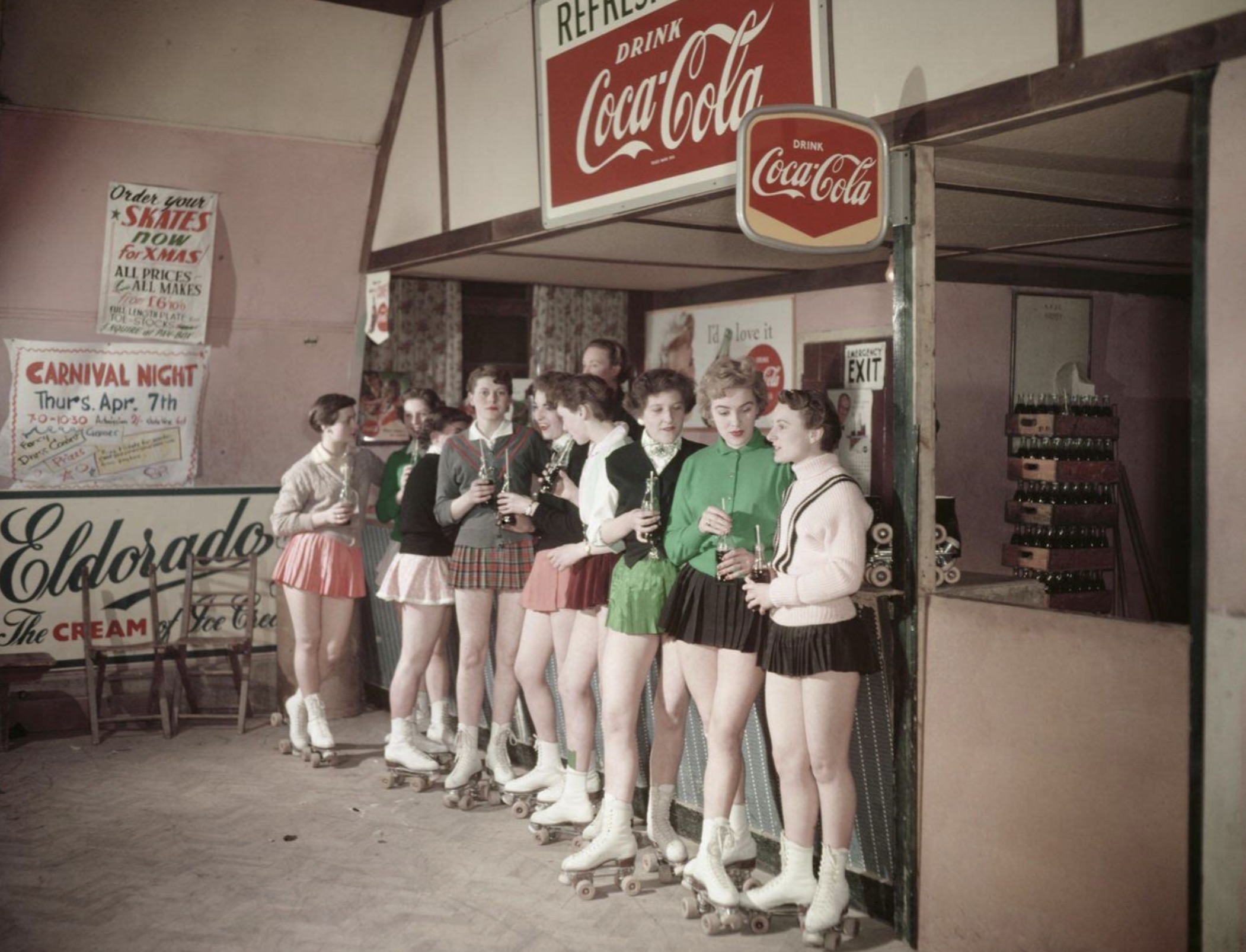 Group of women at the roller skate ring, have a coke while they rest a little. Mid 1950s. 